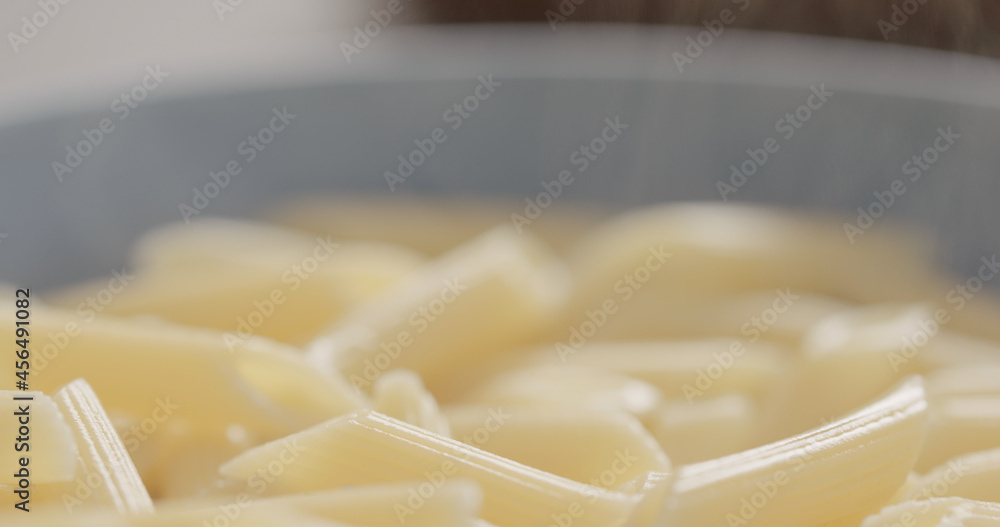 boiled penne pasta in blue bowl closeup boiled penne pasta in blue bowl closeup
