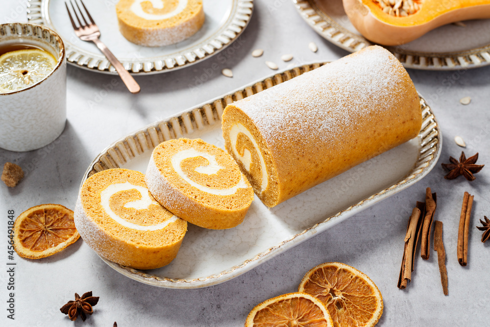 Pumpkin Cake Roll with Cream Cheese Filling. Autumn Baking. Light gray stone background. Pumpkin Cake Roll with Cream Cheese Filling. Autumn Baking. Light gray stone background.