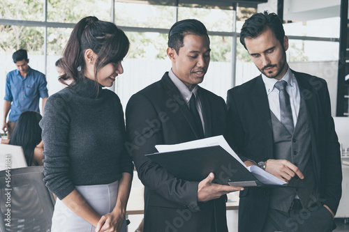 Two businessmen are negotiating a business together with their secretary at the office.