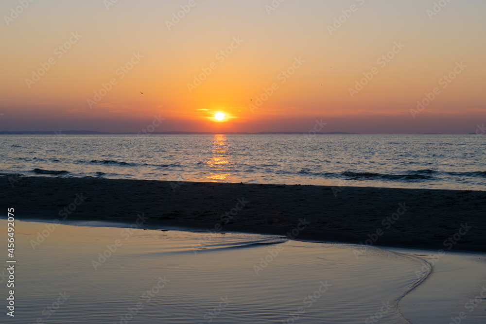 the setting sun against the backdrop of a calm sea