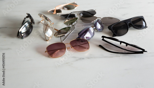 Sun glasses, many different shapes. On a marble background.