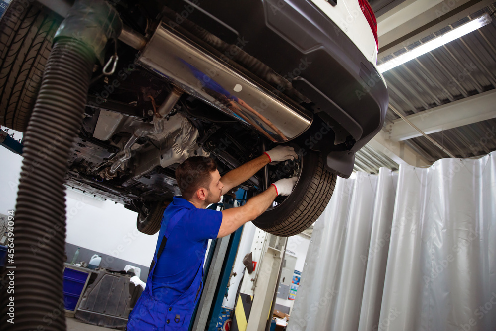 custom made wallpaper toronto digitalCheerful, handsome, and confident car repair specialist in overalls repairs and replaces old parts with new ones in a car on a lift in service