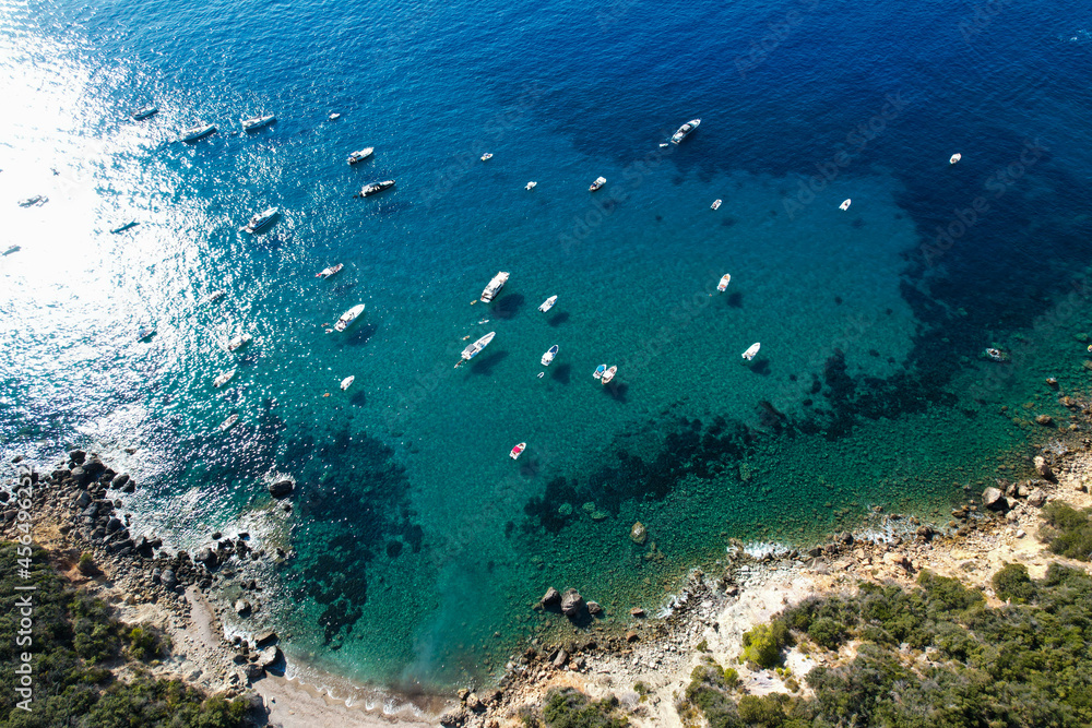 View from above, stunning aerial view of a bay with boats and luxury yachts sailing on a turquoise, clear water surrounded by cliffs. Porto Santo Stefano, Monte Argentario, Italy. View from above, stunning aerial view of a bay with boats and luxury yachts sailing on a turquoise, clear water surrounded by cliffs. Porto Santo Stefano, Monte Argentario, Italy.