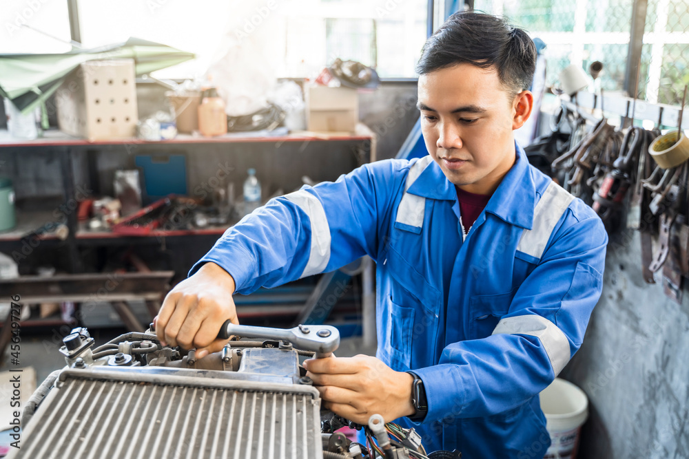 Mechanic Asian man fixing repairing car engine automobile vehicle parts examining screwing using tools wrench equipment working hard in workshop garage support and service in overall work uniform Mechanic Asian man fixing repairing car engine automobile vehicle parts examining screwing using tools wrench equipment working hard in workshop garage support and service in overall work uniform