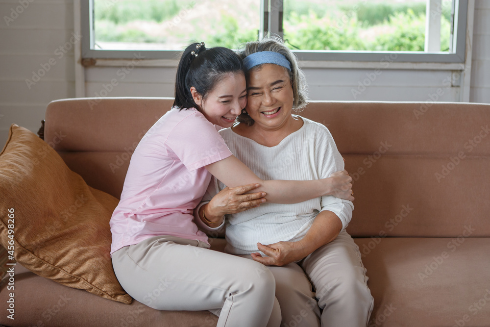 Tag et bad Også Watchful asian adult daughter hug her senior mother on sofa at home . young woman  embrace old mom to take care on couch in living room Stock-foto | Adobe  Stock