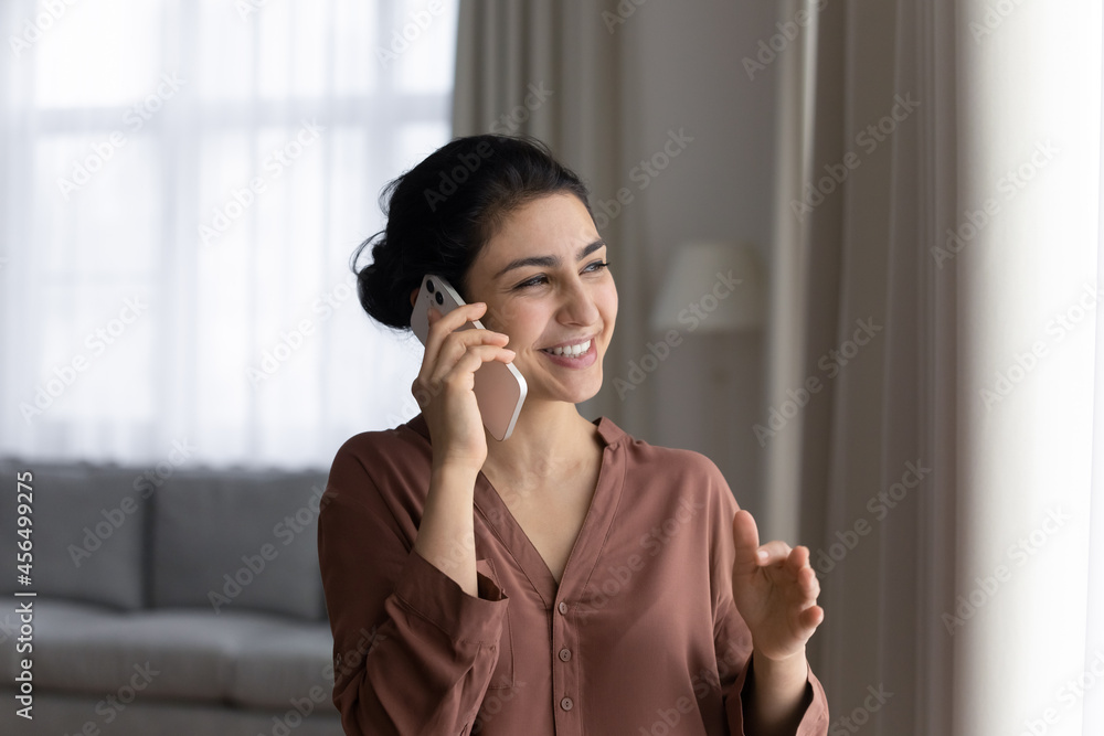 Phone talk. Positive young lady of indian ethnicity speak on telephone hold gadget at ear negotiate affairs. Pleasant hindu woman answer call on cell enjoy conversation with friend business partner Phone talk. Positive young lady of indian ethnicity speak on telephone hold gadget at ear negotiate affairs. Pleasant hindu woman answer call on cell enjoy conversation with friend business partner