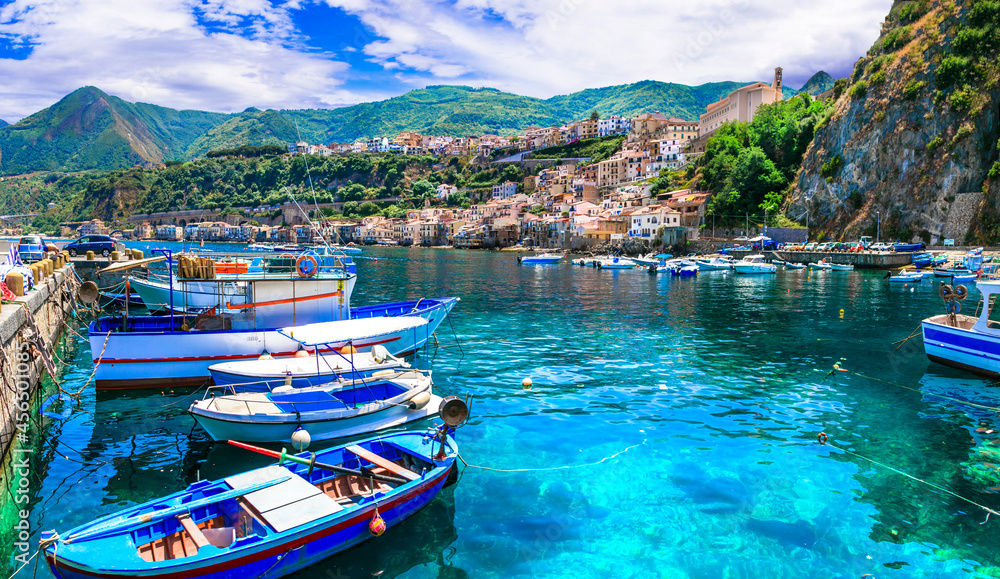 Colorful fishing boats and transparent emerald sea of Calabria. Scilla medieval town. Italy