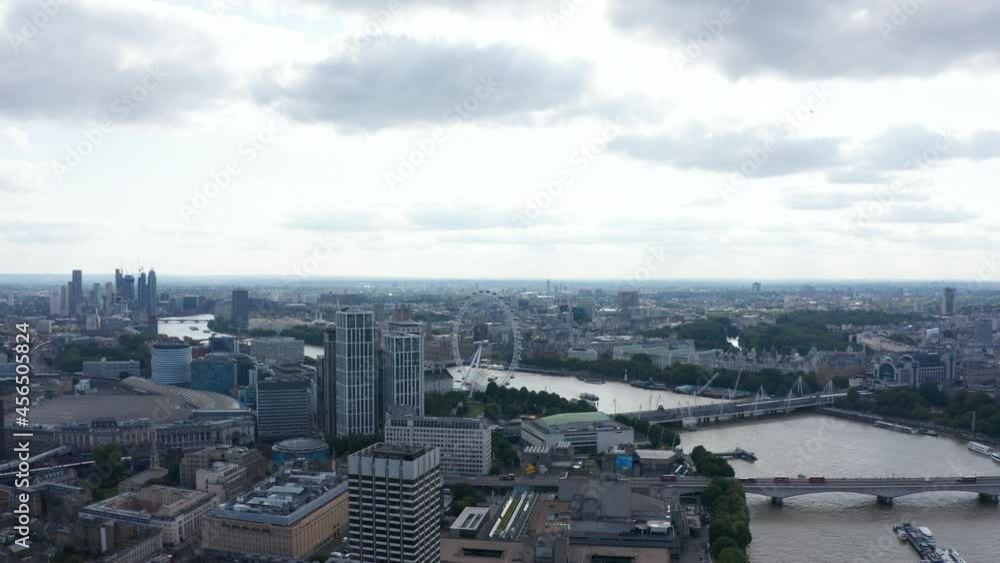 Aerial view of Thames river winding through city. Mixture of historic and modern architecture. Forwards fly against cloudy sky. London, UK Aerial view of Thames river winding through city. Mixture of historic and modern architecture. Forwards fly against cloudy sky. London, UK