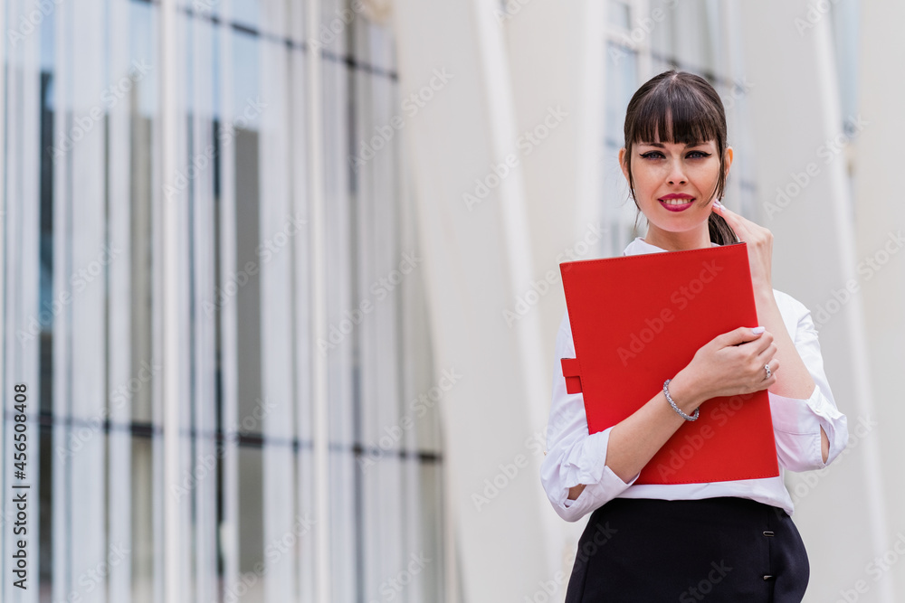 Portrait of beautiful business woman holding notebook on her way to work Portrait of beautiful business woman holding notebook on her way to work
