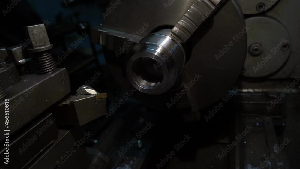 a robot on an old lathe grooving a metal part in a dark workshop a robot on an old lathe grooving a metal part in a dark workshop