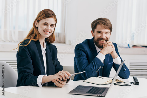 business man and woman sitting at the table in front of laptop professionals technology