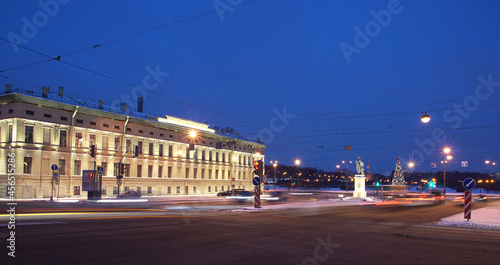 Buildings with glowing lights in winter and a Christmas tree in the square