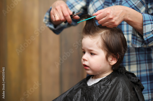 A little boy is trimmed in the hairdresser's bright emotions on face