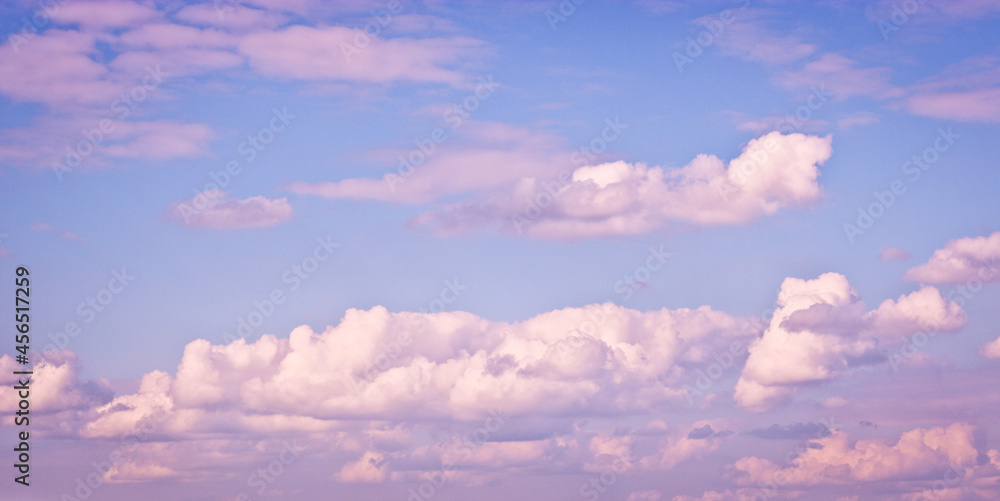 The sky with blurred cirrus and cumulus clouds illuminated by the setting sun. Natural background The sky with blurred cirrus and cumulus clouds illuminated by the setting sun. Natural background