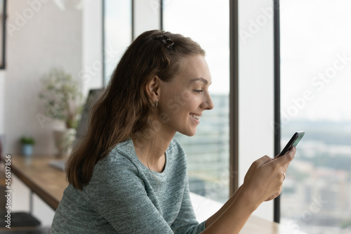 Smiling millennial Caucasian woman use cellphone text message online on modern gadget. Happy young female hold smartphone talk speak on video webcam digital call. Communication, technology concept. Free Download Smiling millennial Caucasian woman use cellphone text message online on modern gadget. Happy young female hold smartphone talk speak on video webcam digital call. Communication, technology concept. - GFXLoad