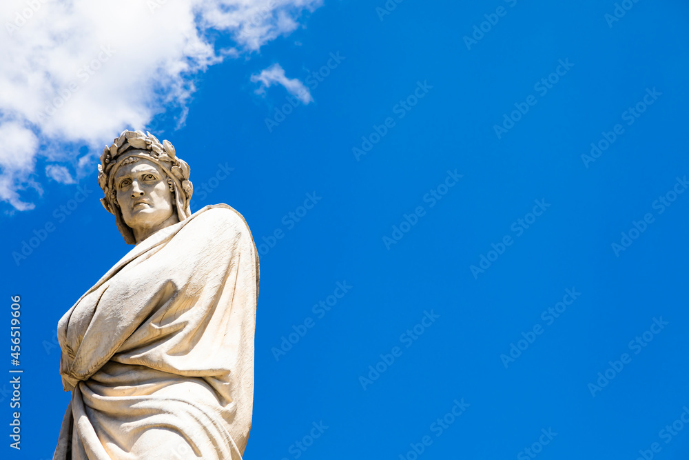 Dante Alighieri statue in Florence, Tuscany region, Italy, with amazing blue sky background.
