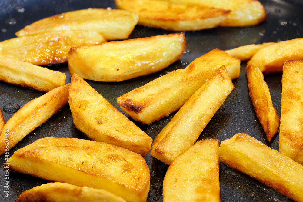 Crisp and golden french fries. Home made deep fried chips. Frying potato on pan. Food cooking background. Close up view. Crisp and golden french fries. Home made deep fried chips. Frying potato on pan. Food cooking background. Close up view.