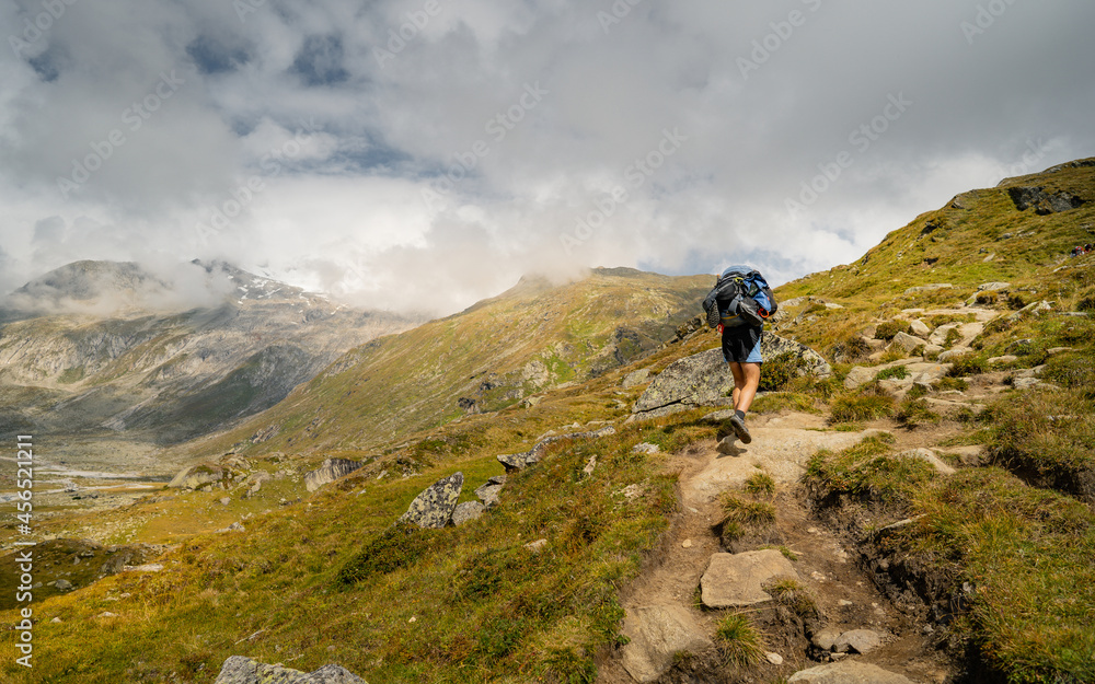 Man hiking in mountains with backpack. Travel sport lifestyle concept. Active weekend summer vacations wild trek