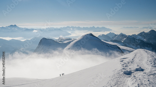 Group alpinists on an adventure ascent on high alpine peak or summit. Fog and mist weather, sharp snow ridge Climbing in high mountain landscape. Grossvenediger, Austria. © Pavel Kašák