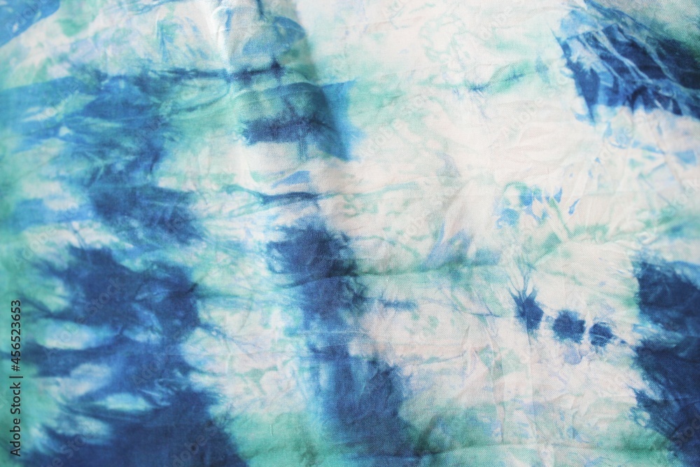 Tie dye green background with half circle layers of dye pattern fading from green to white dye fabric textile Tie dye green background with half circle layers of dye pattern fading from green to white dye fabric textile