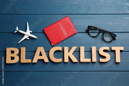 Принти на полотні Word Blacklist of letters, toy airplane and passport on blue wooden background,
