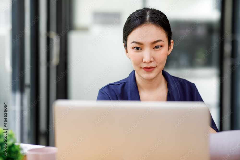 Shot of a asian young business Female working on laptop computer in her workstation.Portrait of Business people employee freelance online marketing e-commerce telemarketing concept. Shot of a asian young business Female working on laptop computer in her workstation.Portrait of Business people employee freelance online marketing e-commerce telemarketing concept.