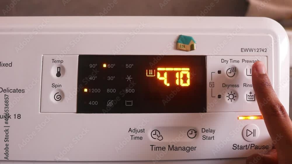 Tanned Hand Adjusting The Pre-Wash Timer Of Washing Machine Tanned Hand Adjusting The Pre-Wash Timer Of Washing Machine