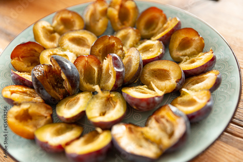  sliced halves of sweet purple plum on a plate