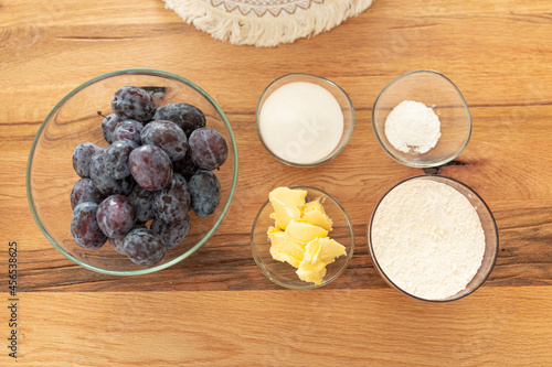 Home cooking baking plum cake with ingredients on wooden table, top view