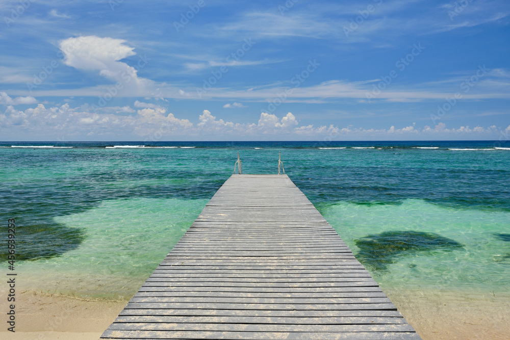 Sandy wooden dock stretches out into the crystal clear and warm waters of the Carribean in the Cayman Islands Sandy wooden dock stretches out into the crystal clear and warm waters of the Carribean in the Cayman Islands