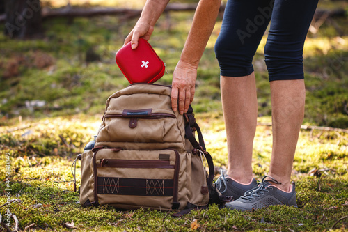 Obraz na płótnie Hiker taking out first aid kit from backpack