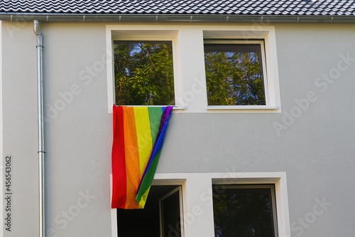 Photography gay rainbow flag hanging from the window of an apartment building during a gay pride parade