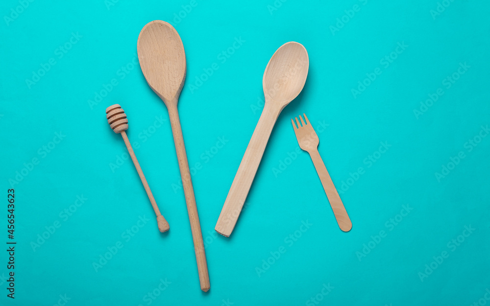 Wooden spoons, fork on turquoise background Wooden spoons, fork on turquoise background