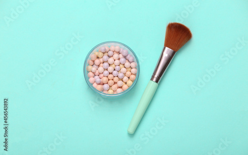 Powder Balls with makeup brush on blue background. Cosmetics. Top view