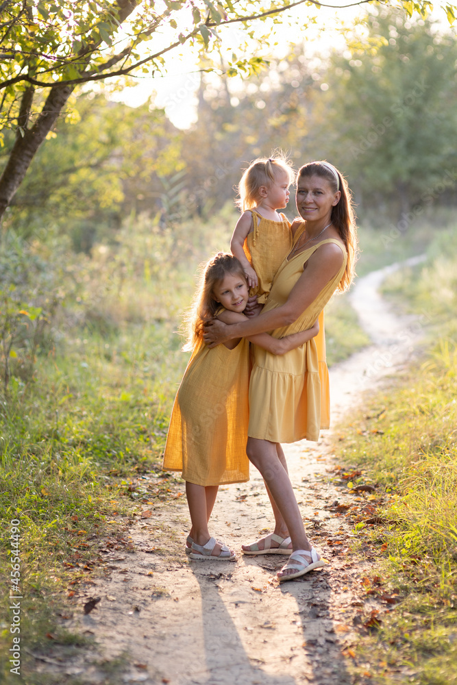 Fototapeta premium Mom and two daughters in nature