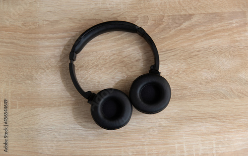 Black headphones on a wooden table.