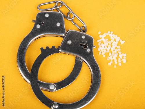 police bracelets and drugs, handcuffs and amphetamine crystals. photo