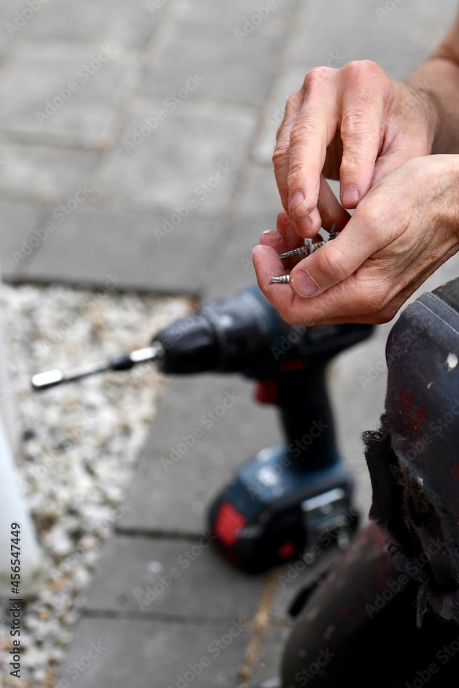 A man holding screws in his hands A man holding screws in his hands