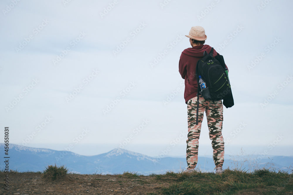 woman on top of the mountain looks into the distance