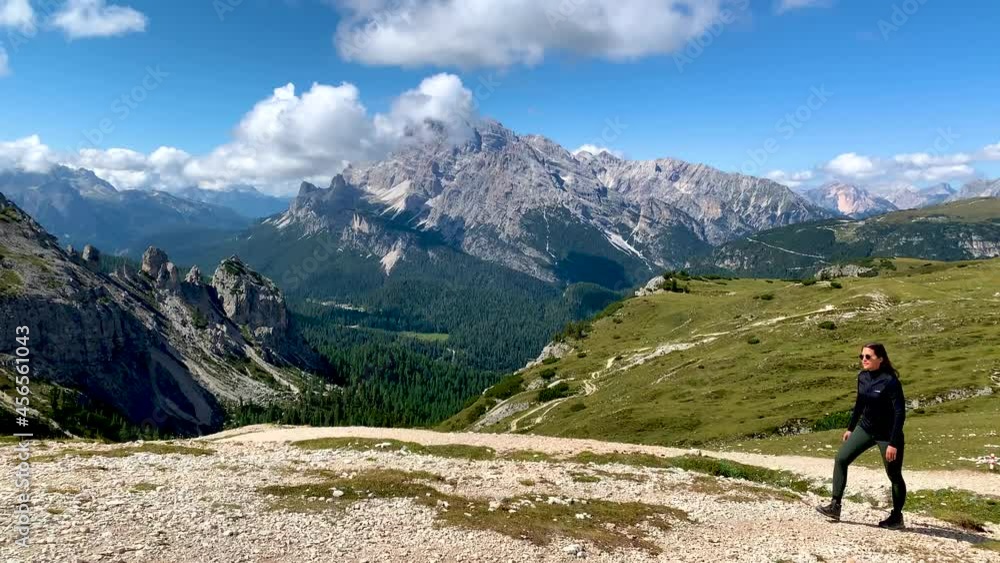 Dolomites, Italy. Women hiker admire beautiful Auronzo di Cadore peaks of Cadini di Misurina mountains group. Tre Cime di Levaredo national park and UNESCO world heritage site Dolomites, Italy. Women hiker admire beautiful Auronzo di Cadore peaks of Cadini di Misurina mountains group. Tre Cime di Levaredo national park and UNESCO world heritage site