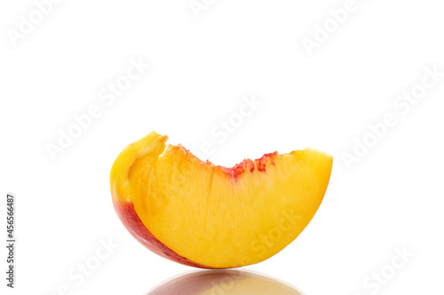 One slice of sweet nectarine, close-up, isolated on white.
