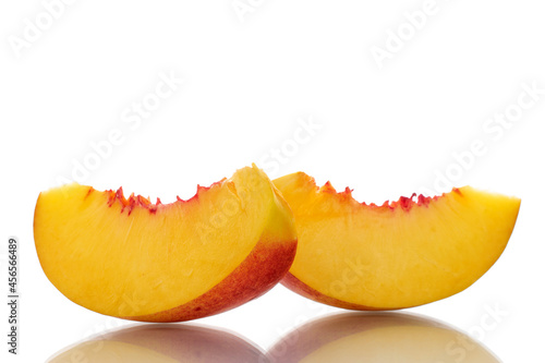 Two slices of sweet nectarine, close-up, isolated on white.
