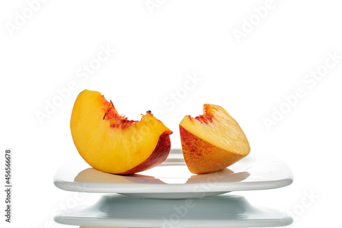 Two slices of sweet nectarine, close-up, isolated on white.