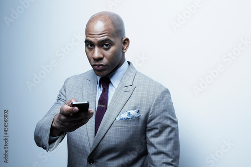 Canvas Print Studio portrait of businessman holding up cellphone