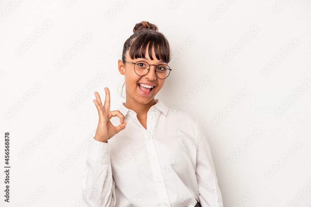 Young mixed race business woman isolated on white background cheerful and confident showing ok gesture. Young mixed race business woman isolated on white background cheerful and confident showing ok gesture.