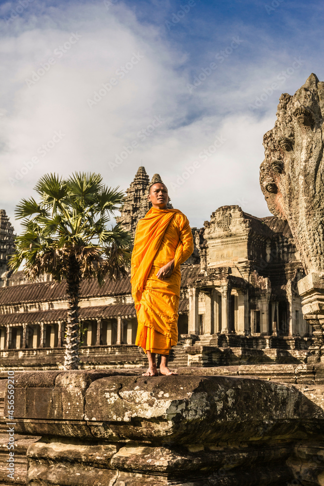 Fototapeta premium Young Buddhist monk standing outside temple in Angkor Wat, Siem Reap, Cambodia