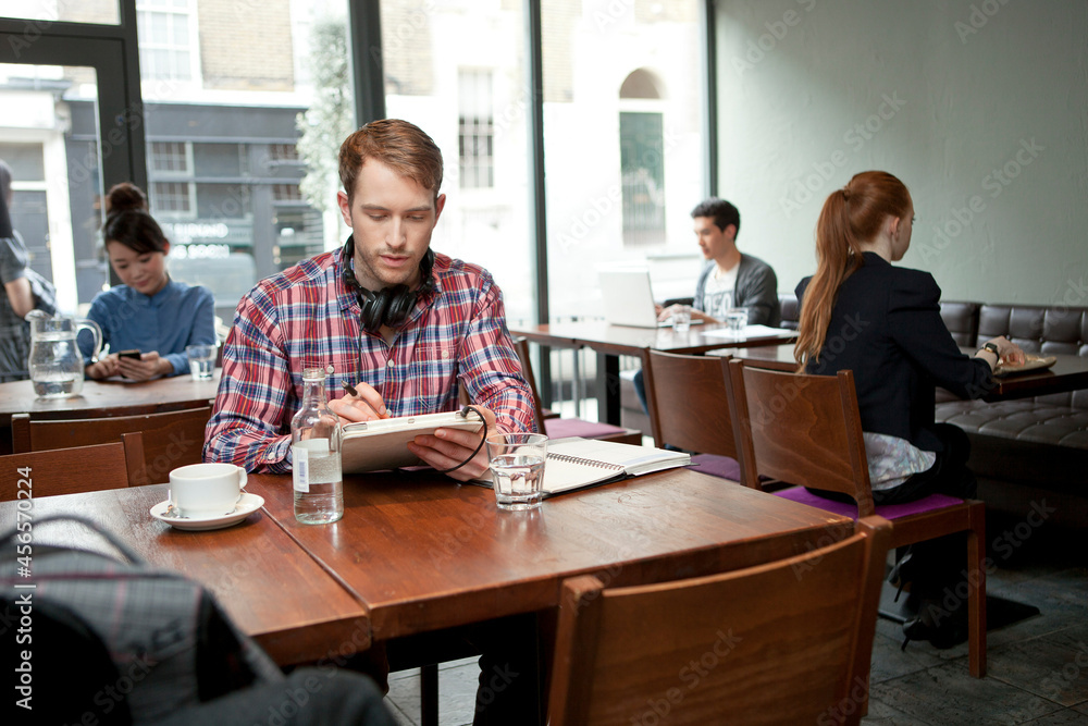 Young man with digital tablet in cafe Young man with digital tablet in cafe