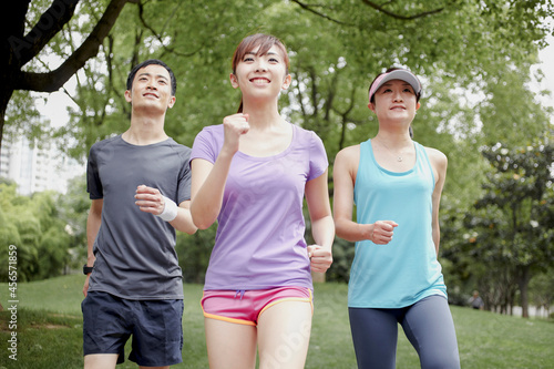 Three young people jogging in park