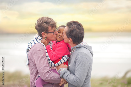 Tableau sur toile Gay couple hugging adopted child