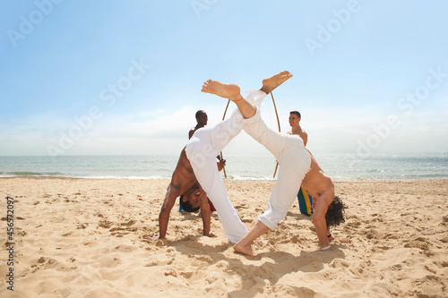 Men doing capoeira on beach